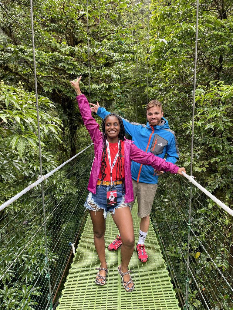 Un garçon et une fille sourient sur un pont suspendu dans la végétation du Costa Rica
