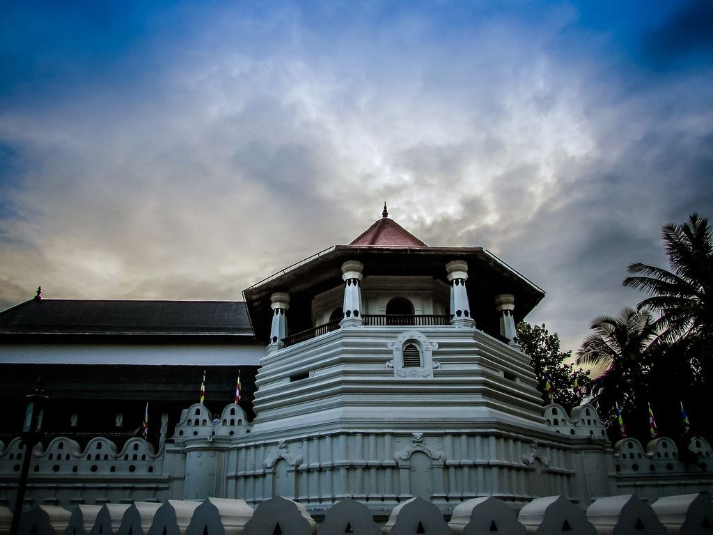 Le Temple de la Dent à Kandy, Sri Lanka, sous un ciel nuageux, avec son architecture traditionnelle blanche.