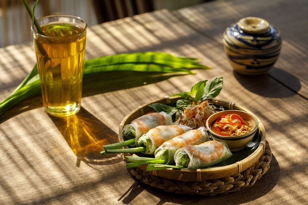 Rouleaux de printemps vietnamiens servis avec sauce et herbes.