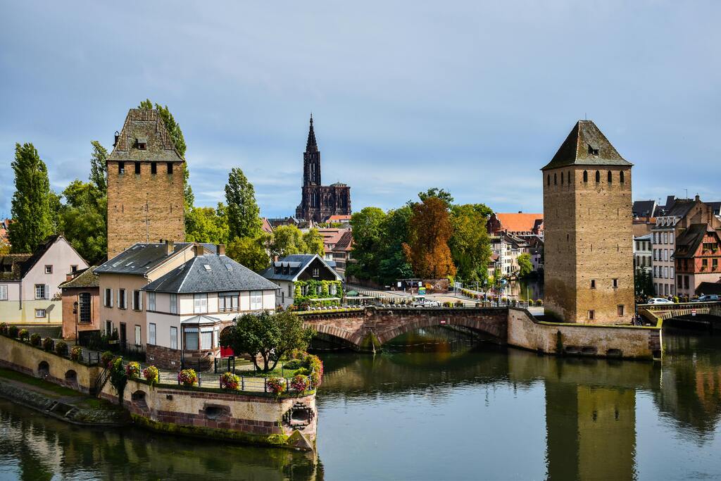 Les ponts couverts de Strasbourg avec la cathédrale visible en arrière-plan, entourés par les eaux paisibles de l'Ill.