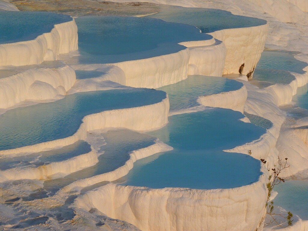 Terrasses de travertin blanches remplies d’eau à Pamukkale, un site naturel emblématique en Turquie.