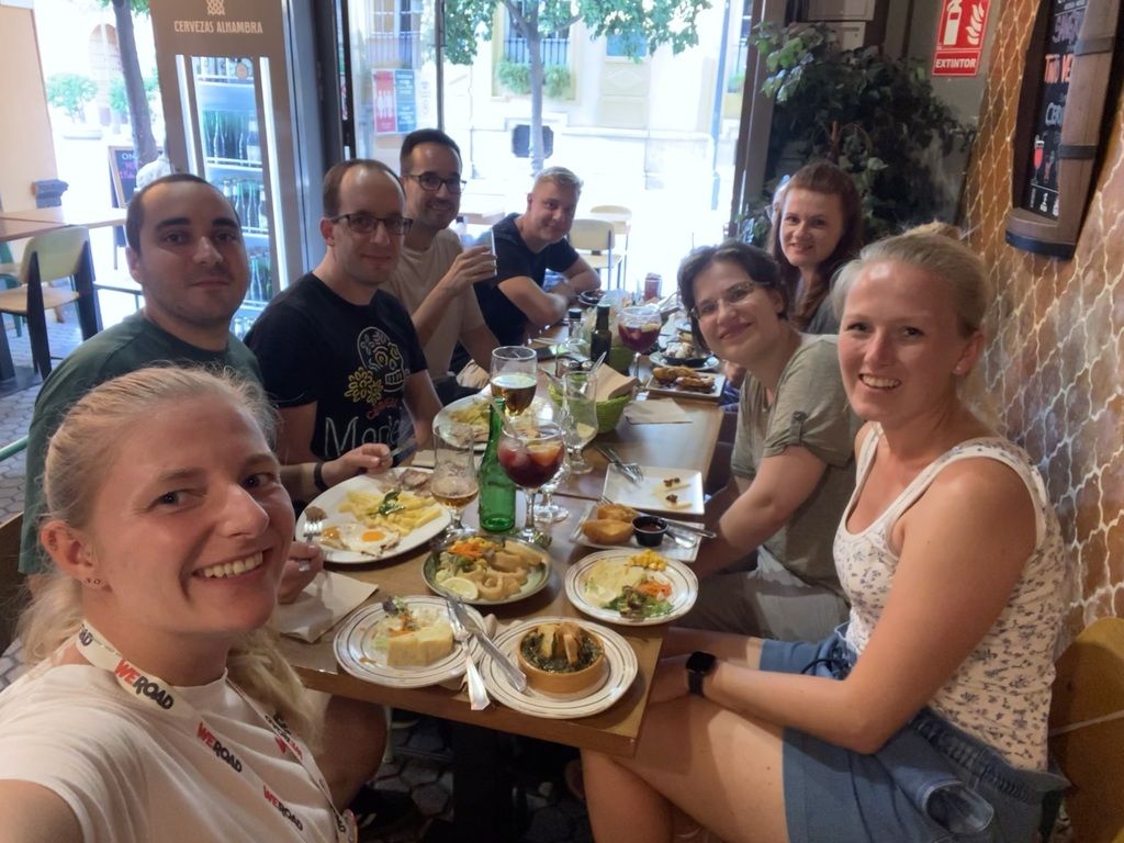 Groupe de voyageurs WeRoad partageant un repas de tapas traditionnelles en Espagne.