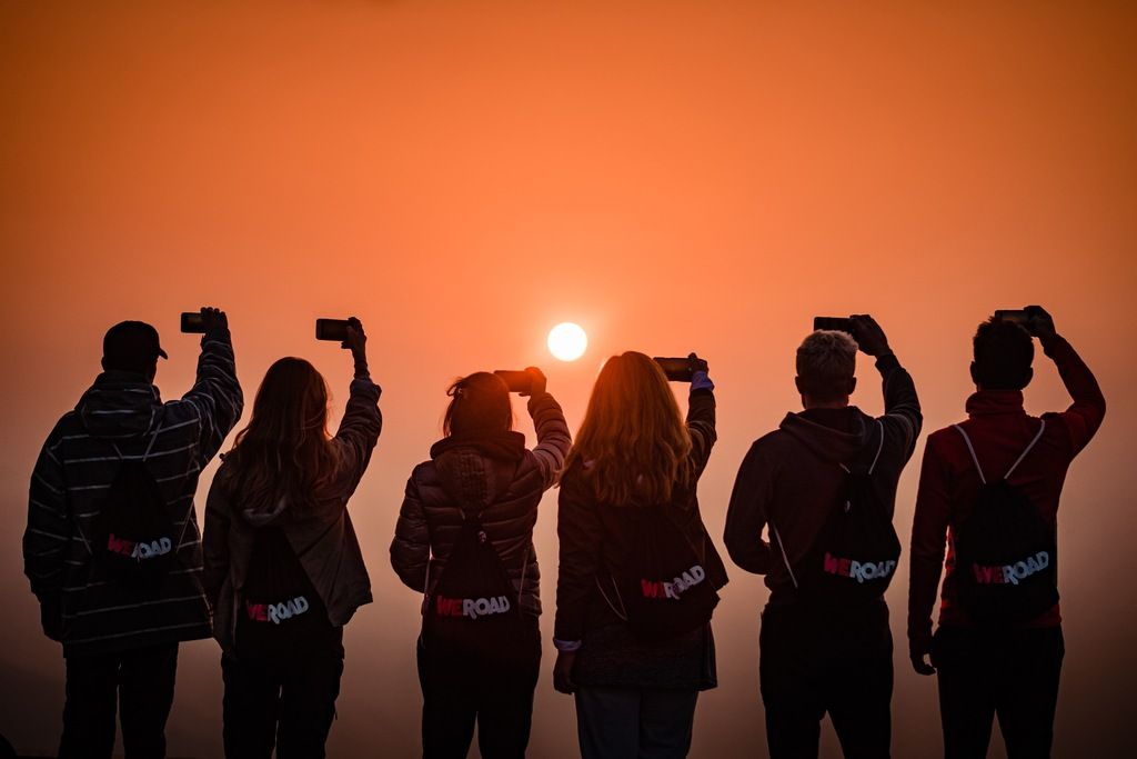 Groupe WeRoad admirant un lever de soleil spectaculaire lors d'un voyage à Prague.