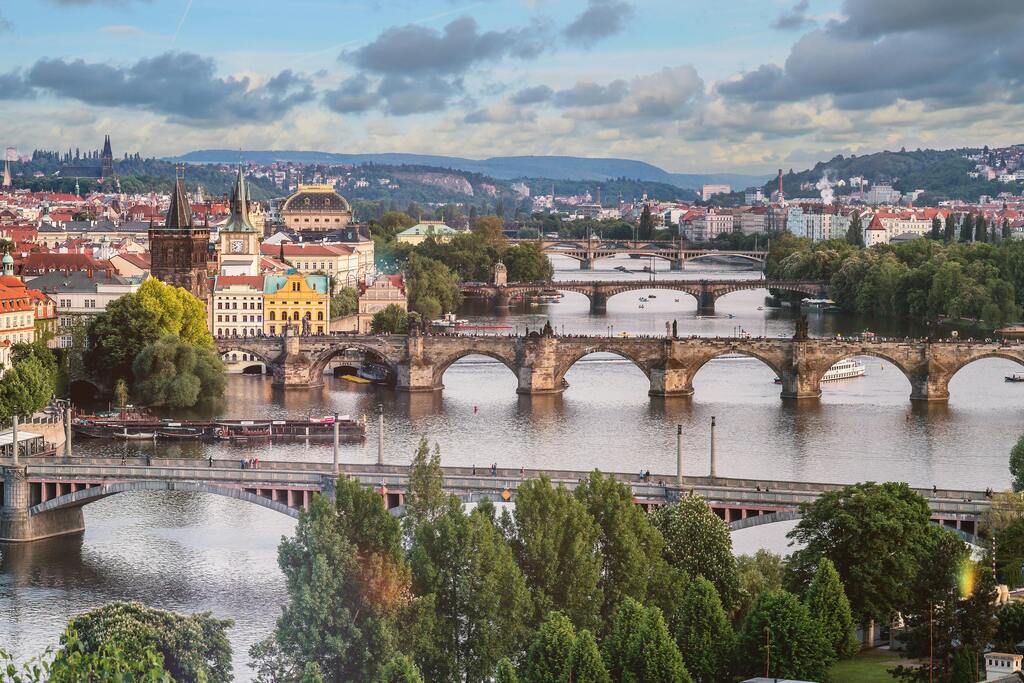  Vue sur les ponts de Prague enjambant la rivière Vltava, avec des bâtiments historiques en arrière-plan.