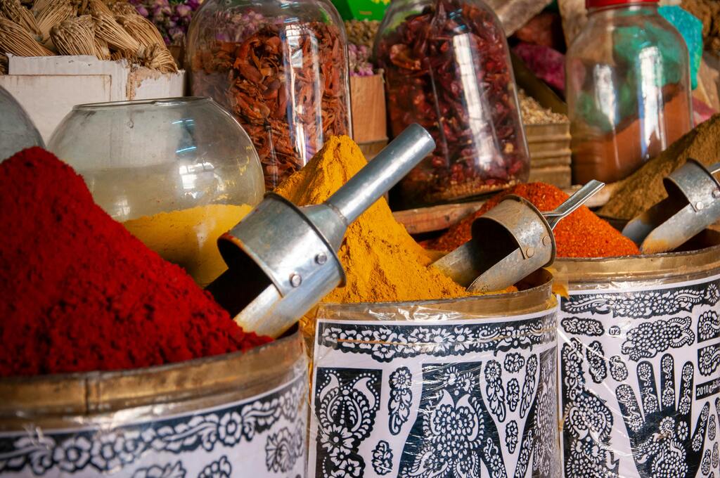 Étal de marché aux épices marocaines, avec des montagnes de curcuma, paprika et autres épices vibrantes.
