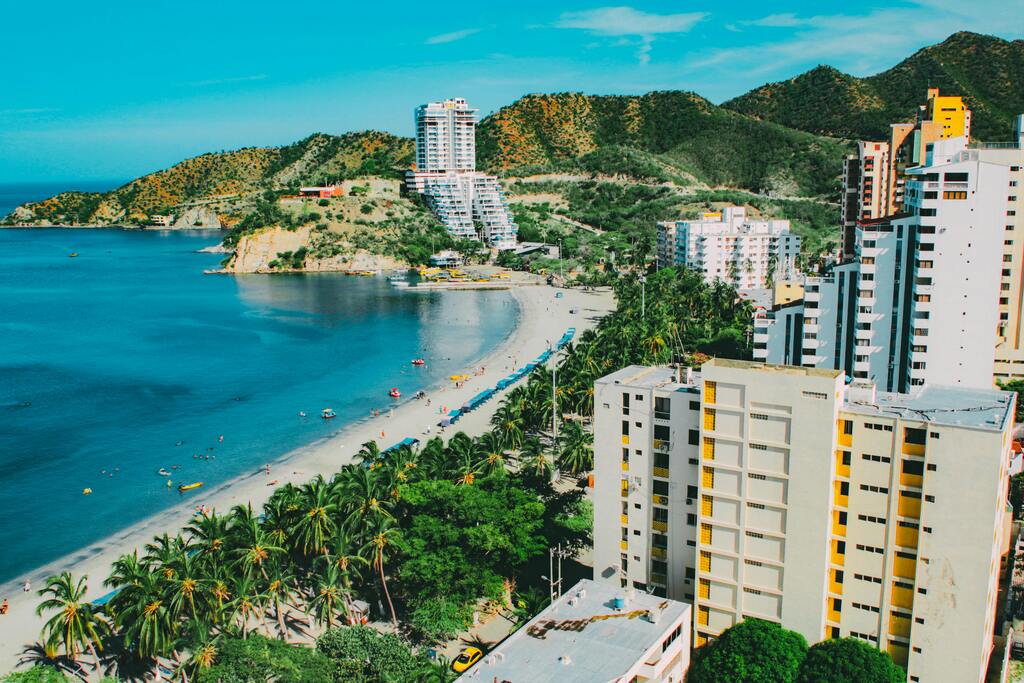 Vue panoramique d'une plage tropicale bordée de palmiers à Santa Marta, en Colombie.