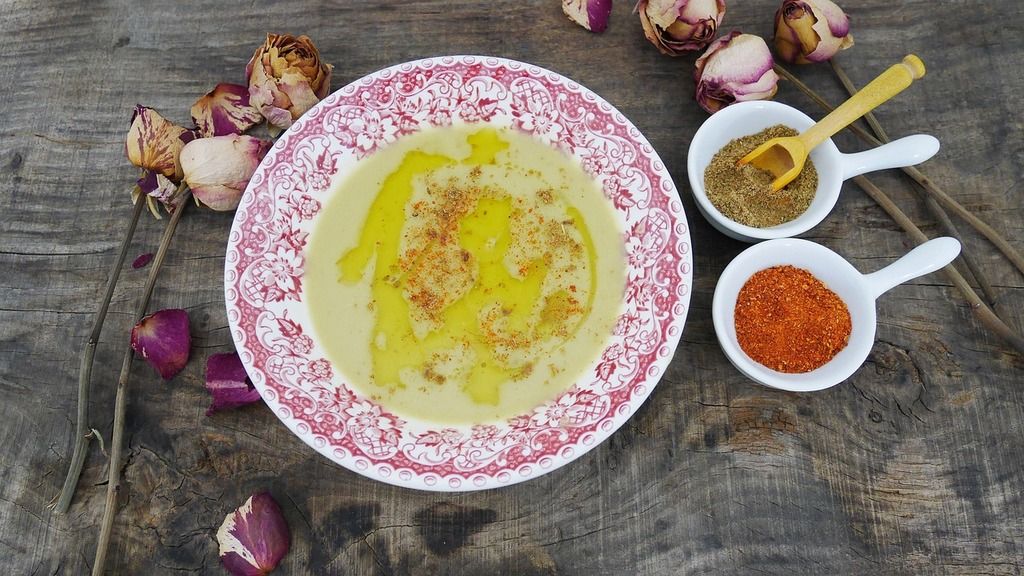 Houmous crémeux à l'huile d'olive, une purée de pois chiches assaisonnée de citron, de tahini et de paprika, accompagnée d’épices.
