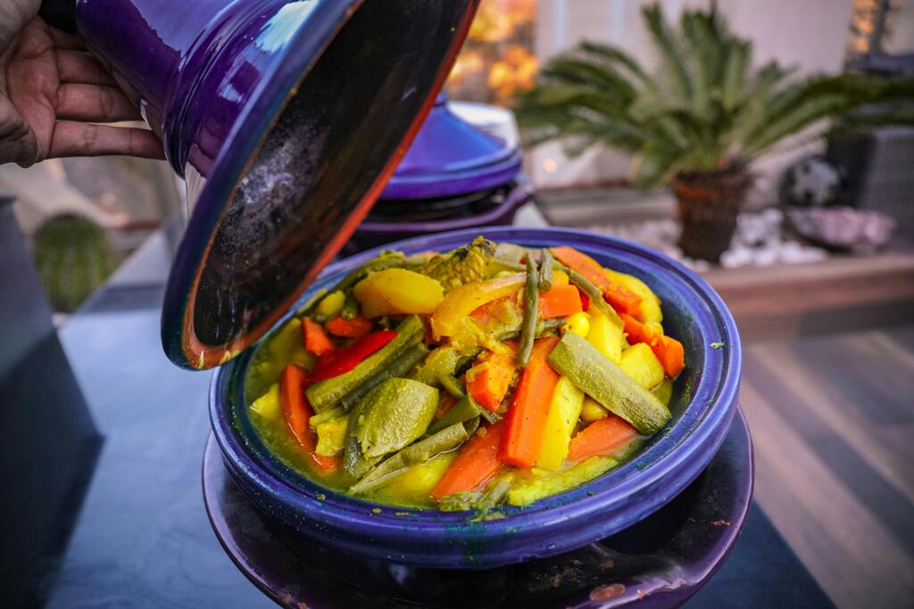 Tagine marocain aux légumes, un plat traditionnel mijoté avec des légumes colorés et des épices parfumées, servi dans un plat en terre cuite.