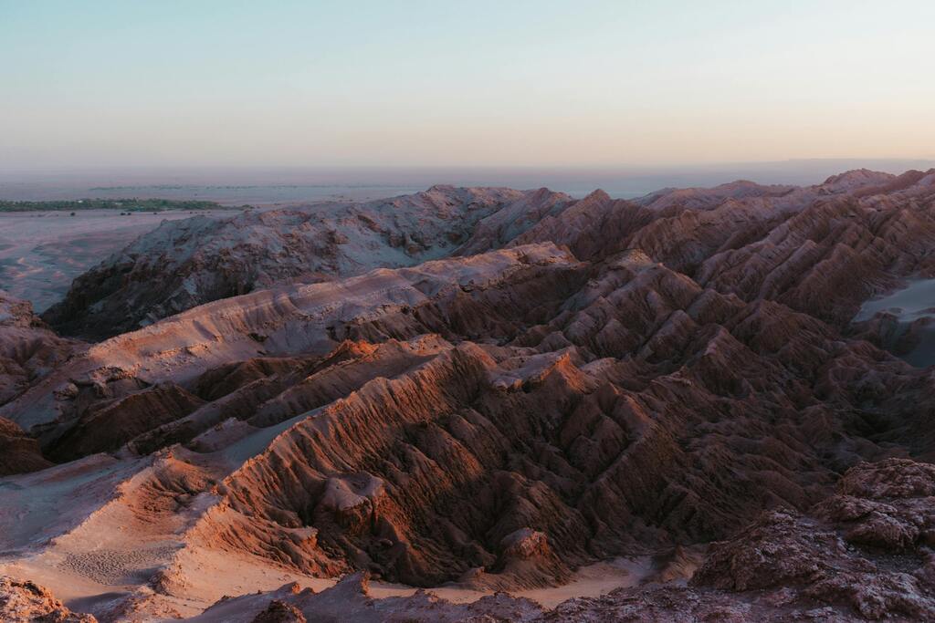 Vallée de la Lune au coucher du soleil, désert d'Atacama, avec des formations rocheuses spectaculaires et des couleurs ocres.