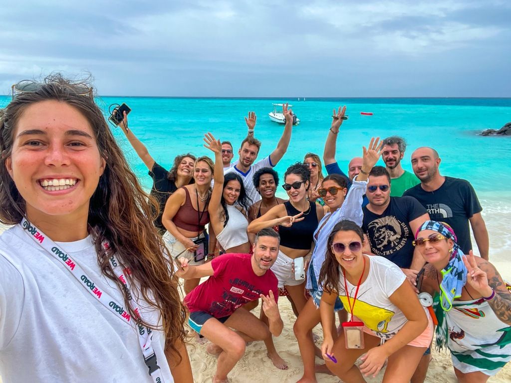 Groupe de voyageurs WeRoad profitant d'une plage tropicale aux Maldives, souriant et posant pour une photo.