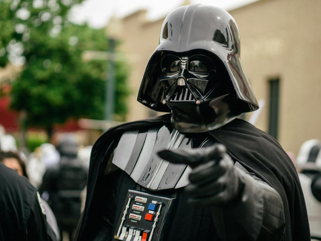 Cosplay de Dark Vador pointant du doigt lors d'un événement en plein air
