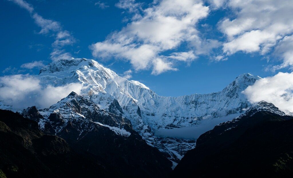 Montagne enneigées sous un ciel bleu avec quelques nuages