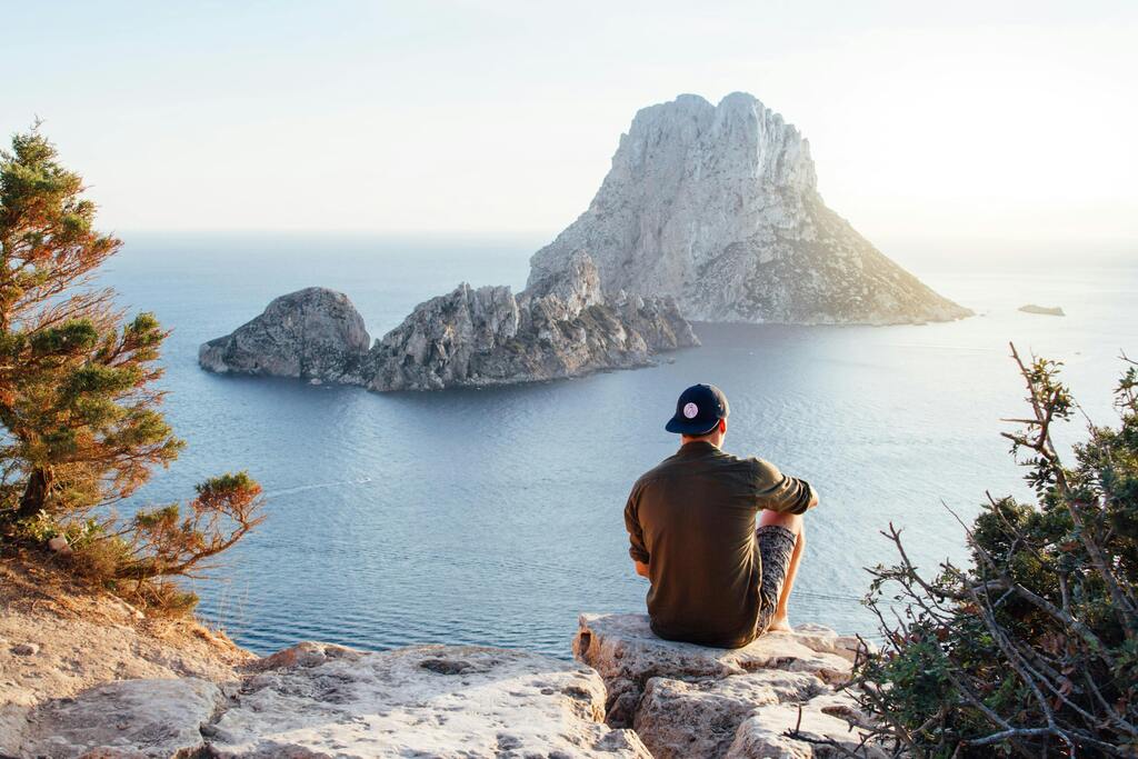 Homme admirant la vue sur l'île rocheuse d'Es Vedrà à Ibiza