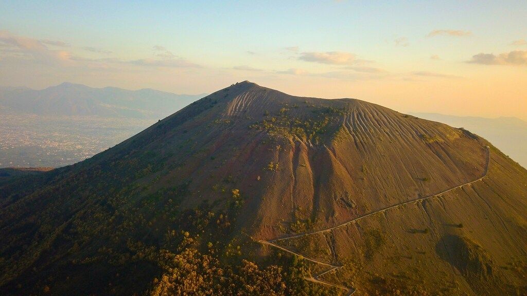 Vue aérienne du Vésuve au coucher du soleil avec un sentier serpentant jusqu'au sommet