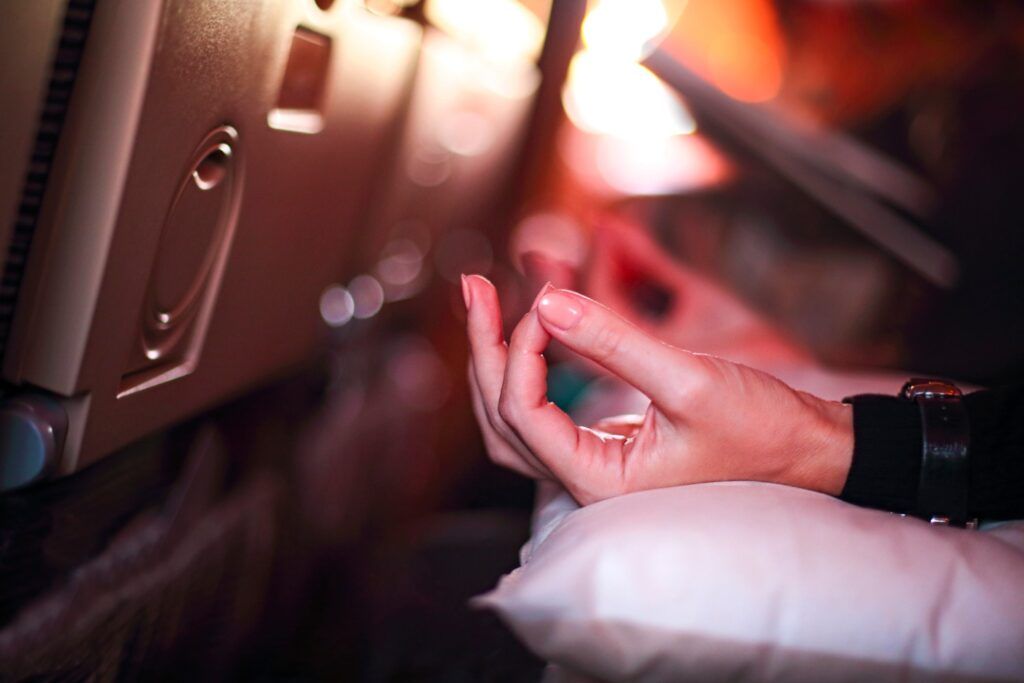 Main en position de méditation sur un oreiller dans un avion, pour aider à vaincre la peur de voler.