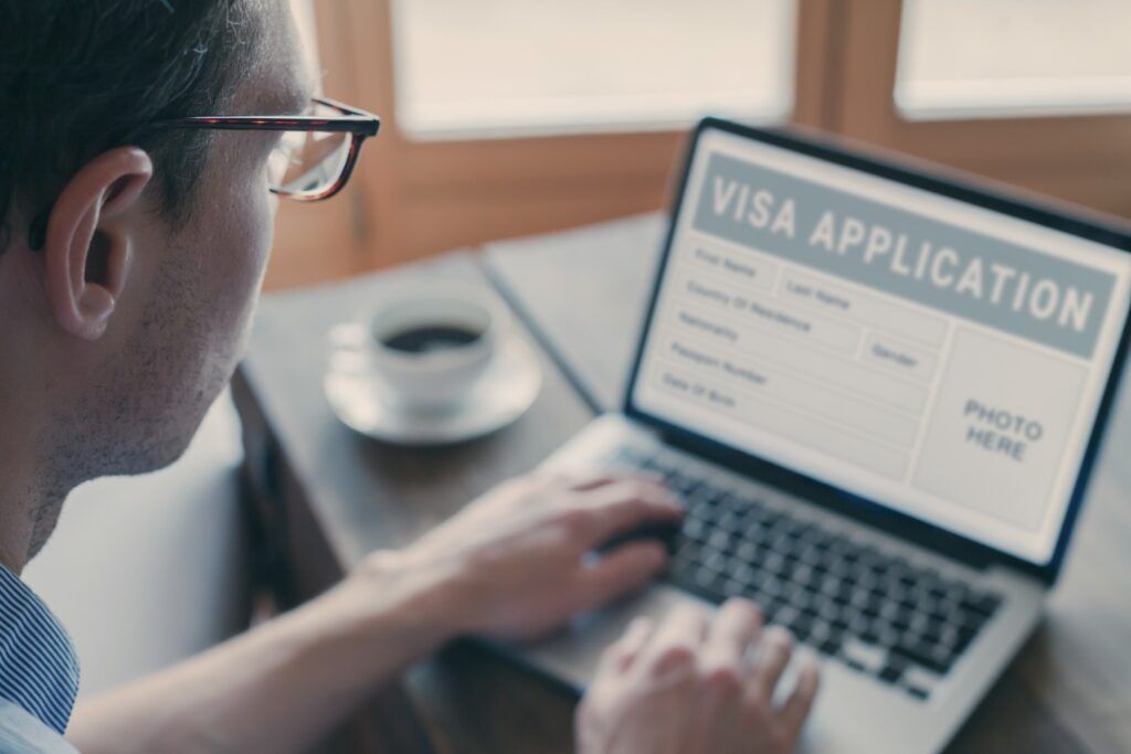 Homme remplissant un formulaire de demande de visa en ligne.