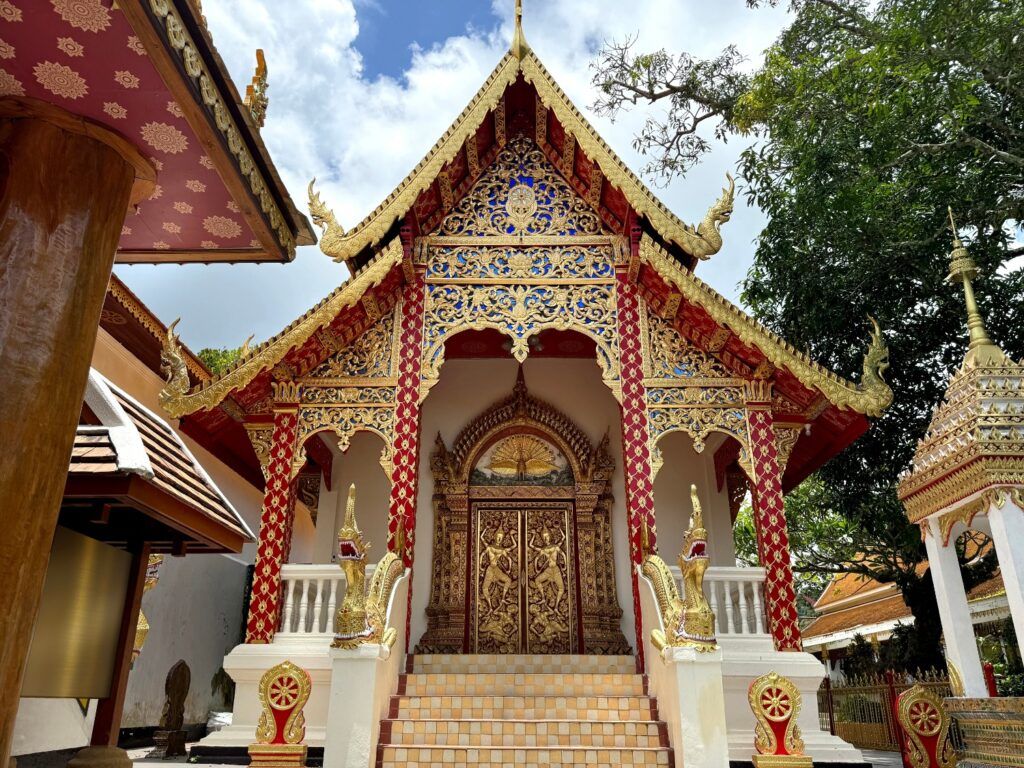 Le majestueux stupa doré du Doi Suthep sous un ciel bleu, orné de lanternes.