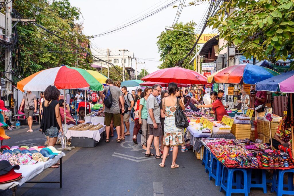 Scène colorée d'un marché de rue très fréquenté en Thaïlande.